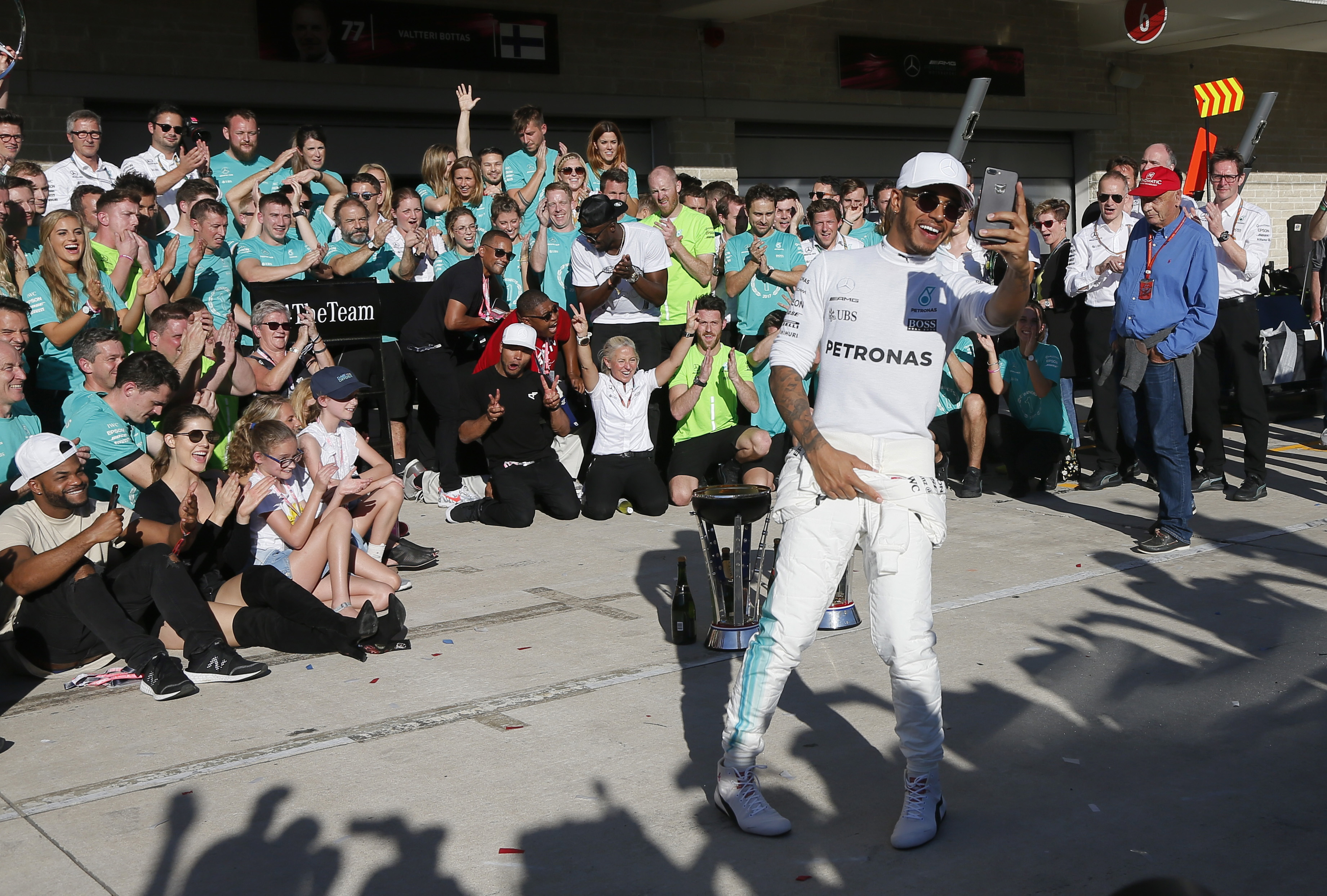 Mercedes driver Lewis Hamilton, foreground, of Britain, takes a photo as he celebrates his win in the Formula One U.S. Grand Prix auto race at the Circuit of the Americas- AP